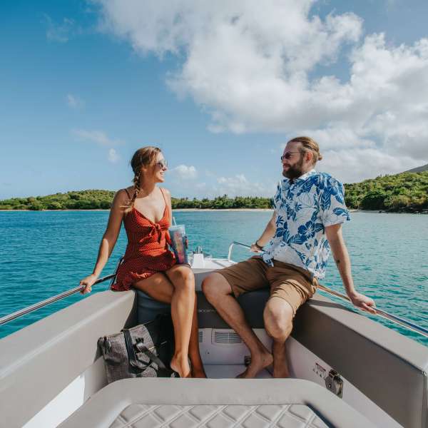 a woman sitting on a dock next to a body of water